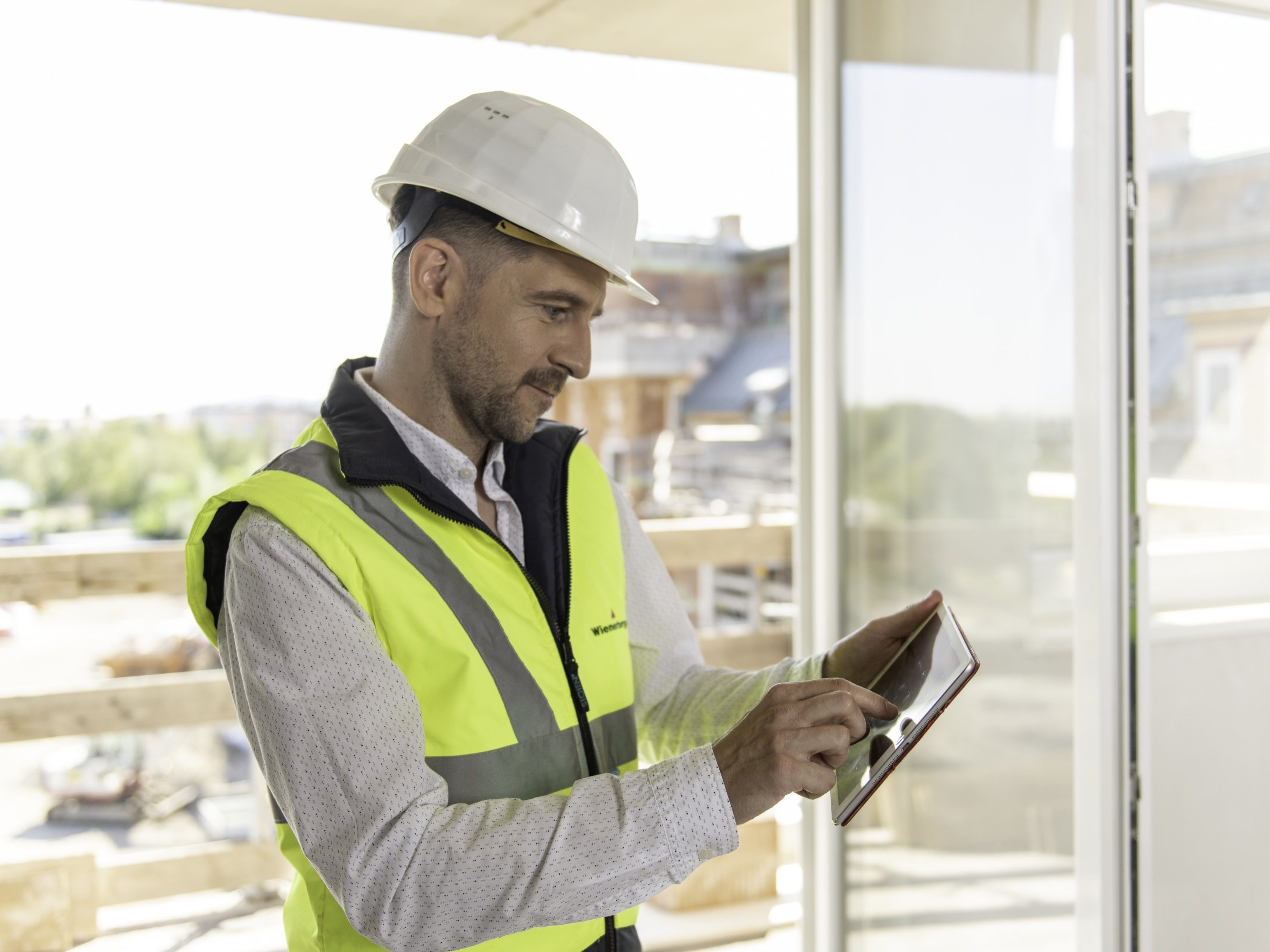 Architect or project manager using mobile device at construction site