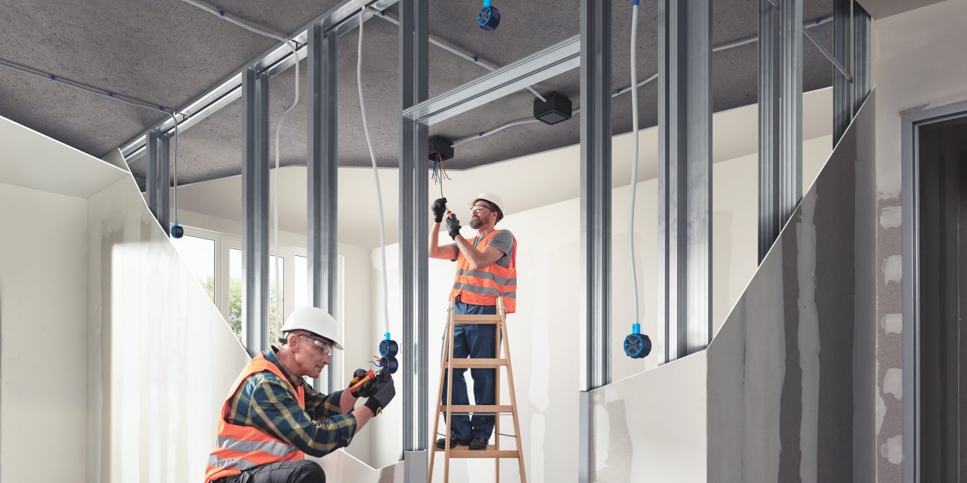 Two electricians installing electrical system  