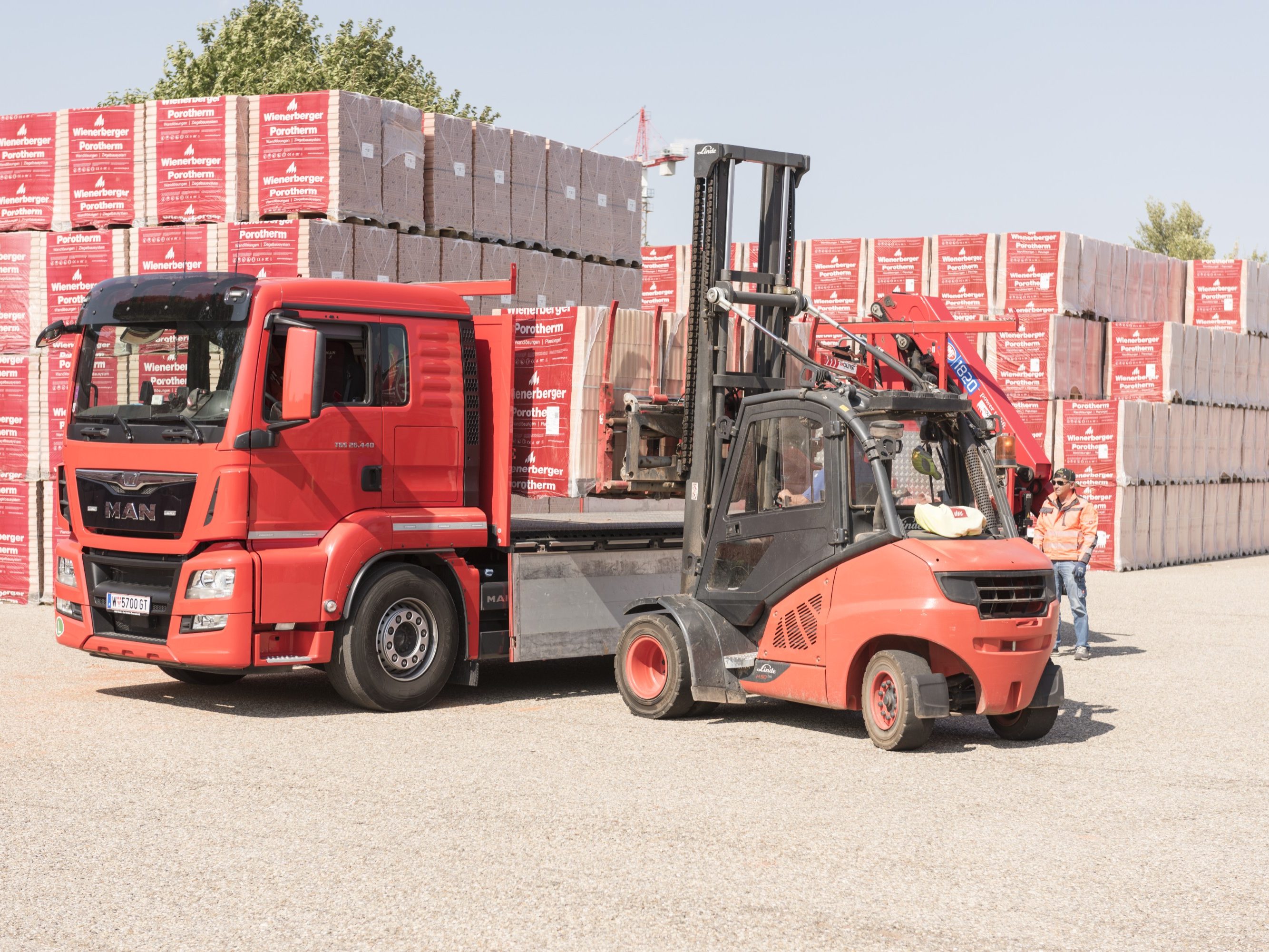 Forklift loads clay block pallets onto truck at stockyard