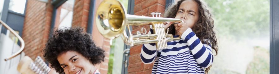 Noisy kids playing electrical guitar and trumpet inside well insulated brick-built house