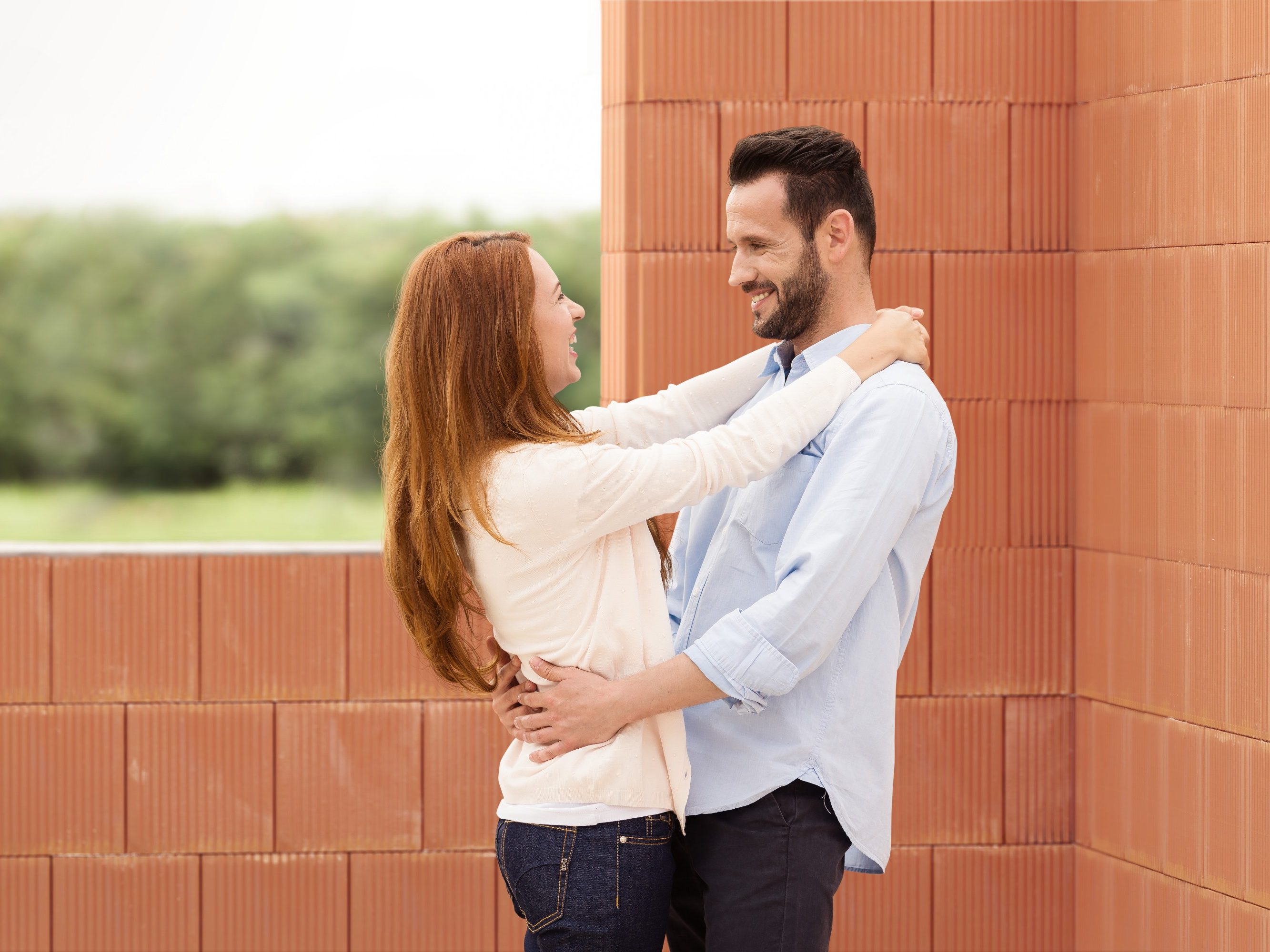 Man and woman celebrating their future home inside building shell