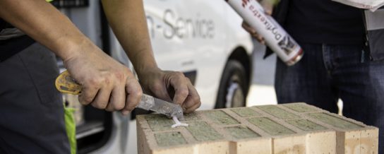 Field service employee at construction site supporting building professional explaining use of Dryfix in front of van