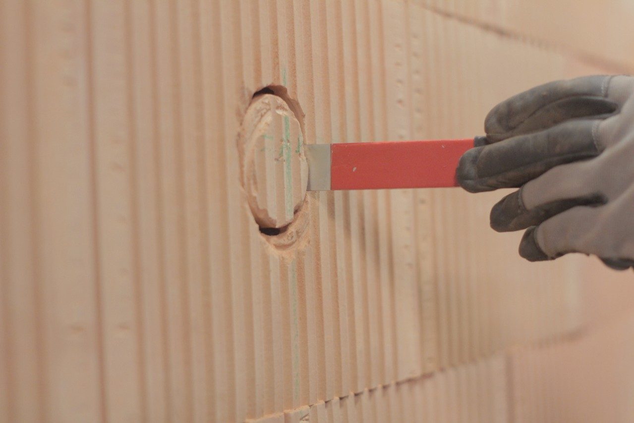 Male hand extracting the rest of a brick from brick wall