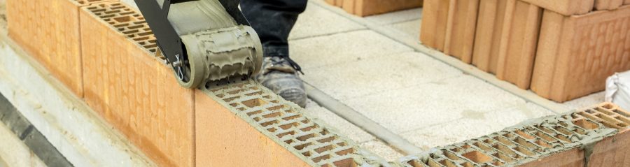 An image of ZeroPlus mortar being applied by a roller onto Porotherm block.