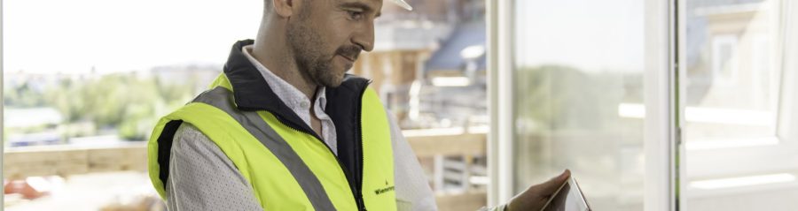 Architect or project manager using mobile device at construction site